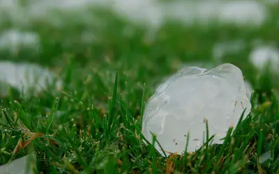 Hail stones on the ground near a residential solar panel array