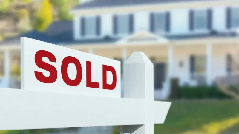 Home for sale sign in front of house