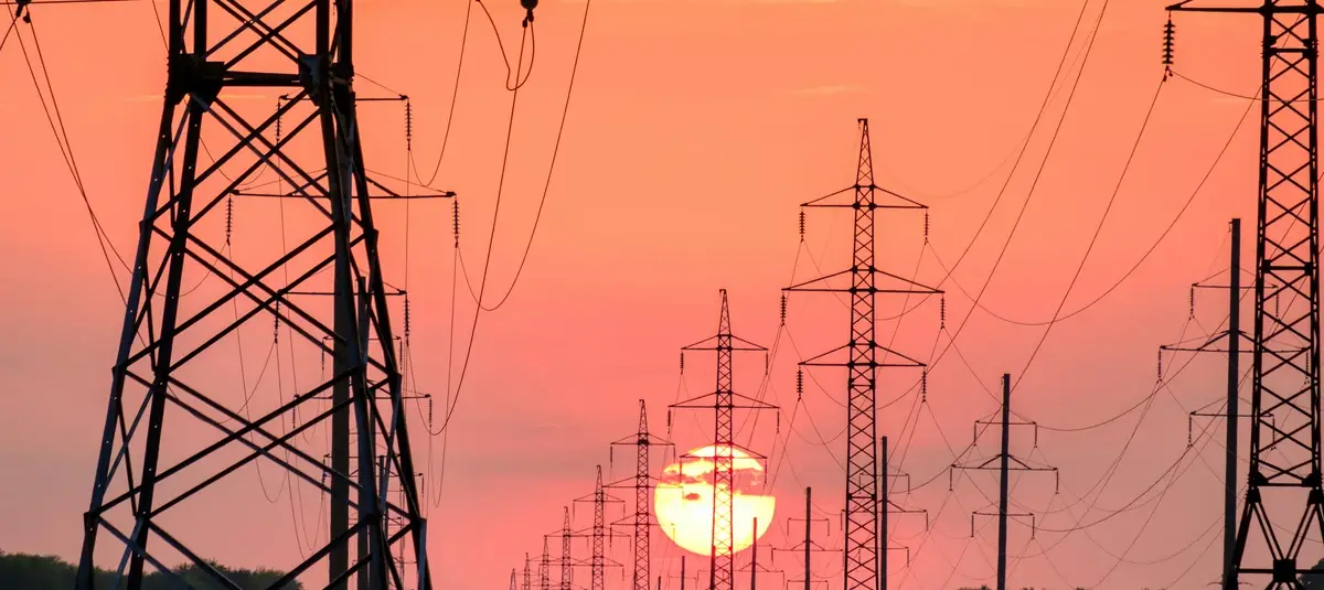 Power lines with sun setting behind them