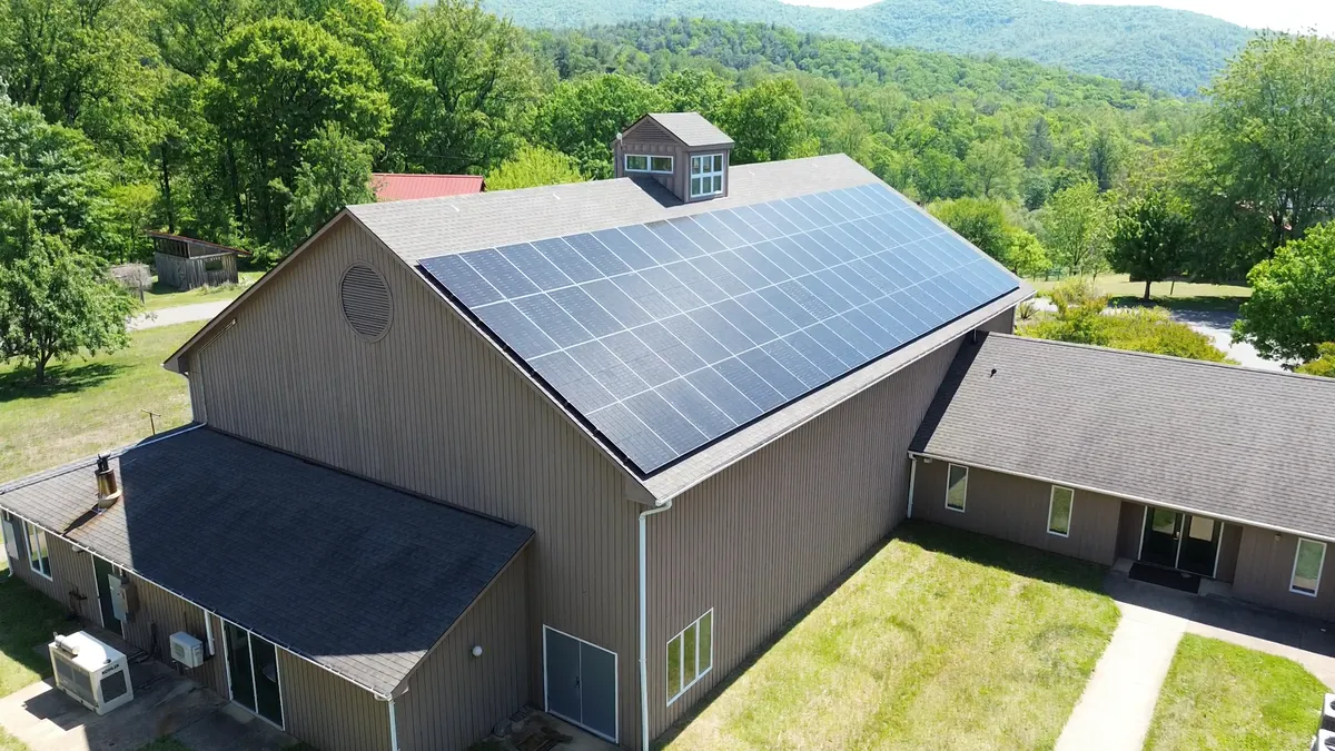Solar panels on a community center roof with the Blue Ridge mountains behind, in Virginia