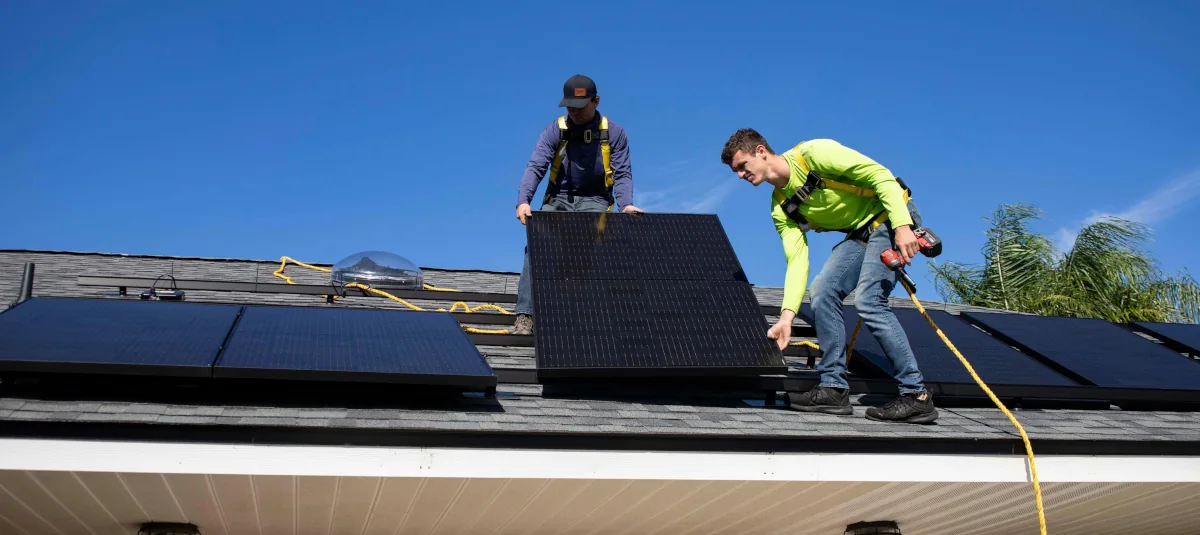 Solar panel installation crew mounting panels on a residential roof
