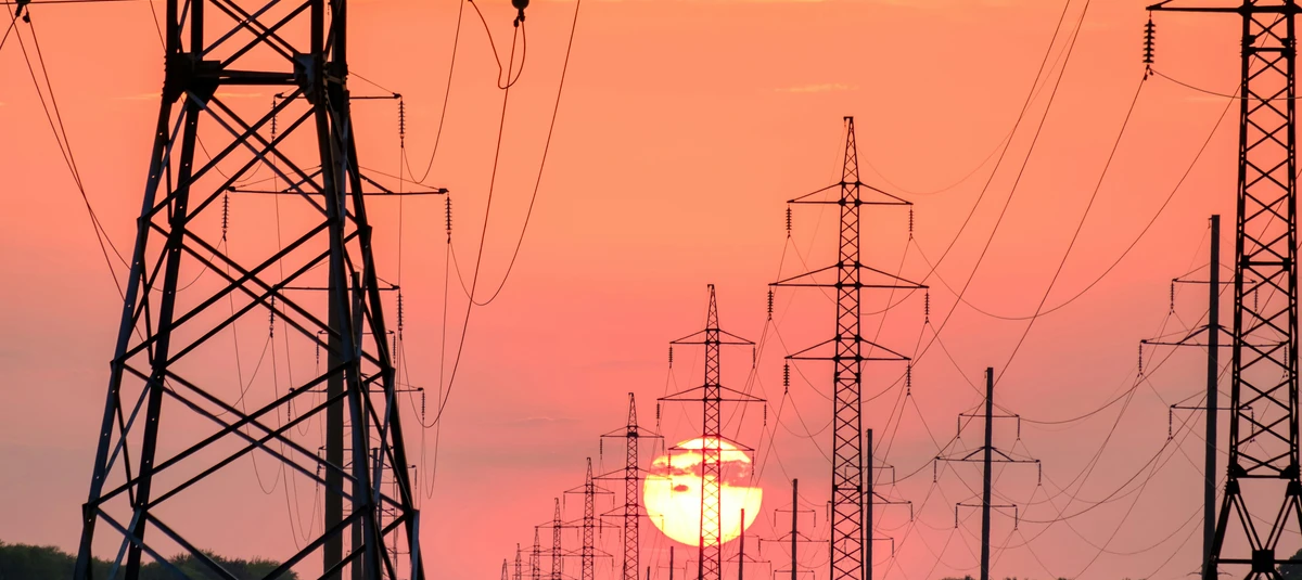 Power lines with sun setting behind them