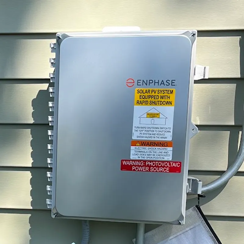 Enphase IQ Combiner mounted on the outside wall of a house with its cover closed